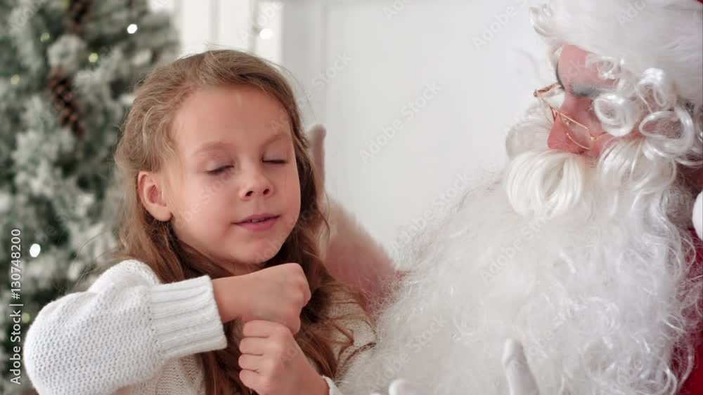 Little girl showing Santa Claus a magic trick with a disappearing finger Little girl showing Santa Claus a magic trick with a disappearing finger