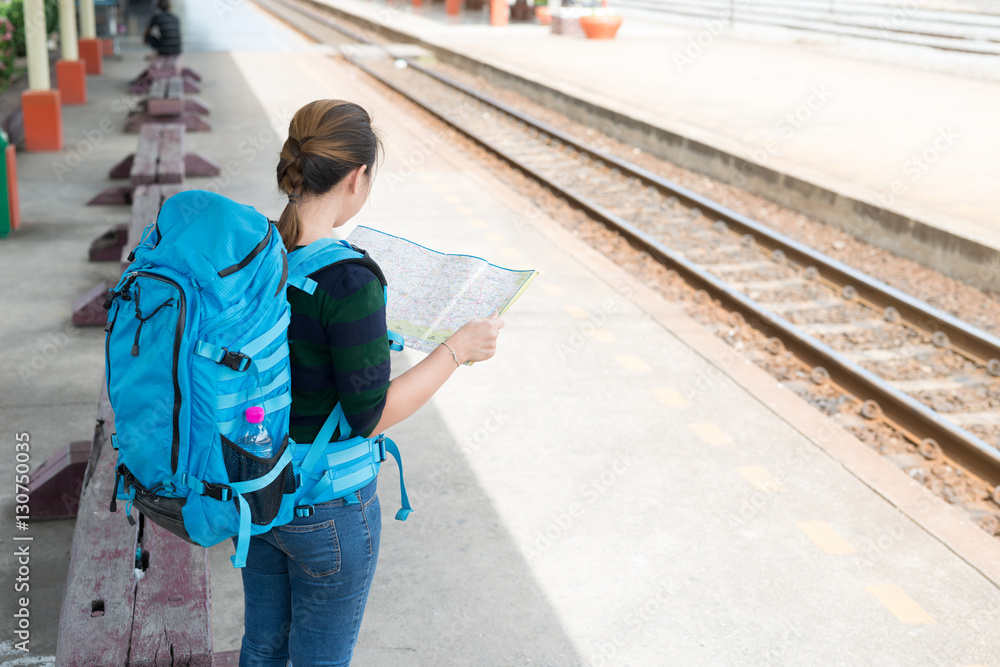 woman backpackers travel searching direction on  map at the train station with a traveler. Travel concept