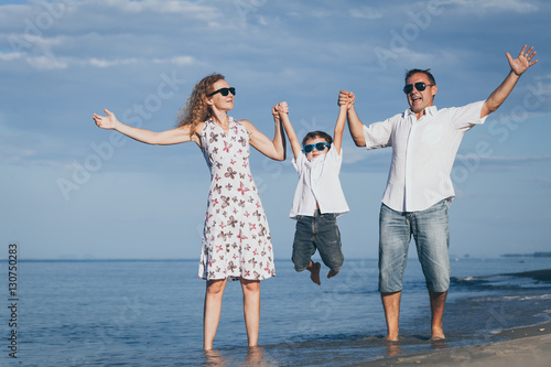 Happy family walking on the beach at the day time.