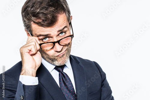 Fotografie pouting far-sighted elegant businessman moving eyeglasses down for disappointmen