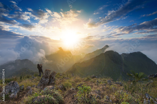 View from the highest mountain peak of Chiang Dao with beautiful cloudy sunset sky and a photographer standing shooting photo, Chiang mai, Thailand