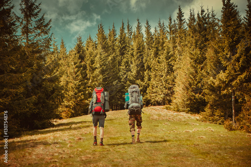 Two young man hiking in forest mountains in summertime. Carpathians, Ukraine, Europe. Beauty world. Vintage filter