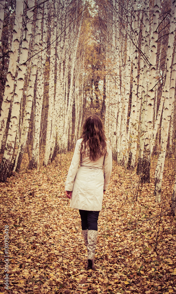 Woman walking on fallen leaves Woman walking on fallen leaves