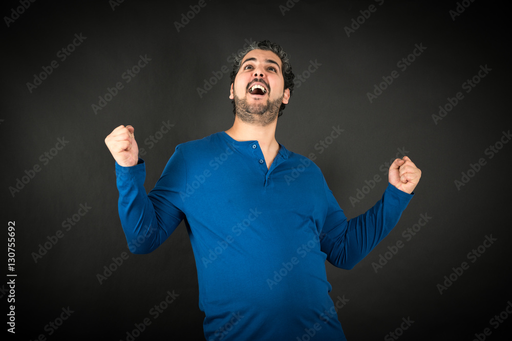 Naklejka premium Handsome man doing different expressions in different sets of clothes: arms raised