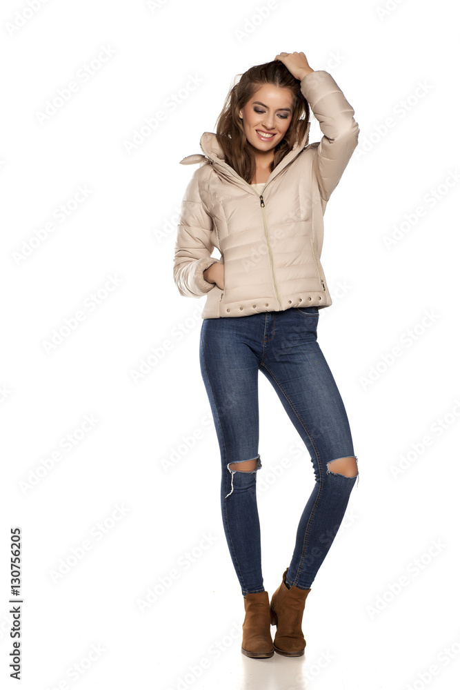 young woman in a winter jacket and jeans on the white background young woman in a winter jacket and jeans on the white background