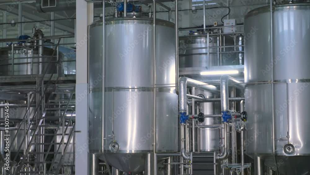 Shiny stainless steel storages, valves and pipes in a modern dairy. 4K. Shiny stainless steel storages, valves and pipes in a modern dairy. 4K.