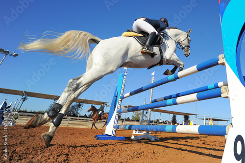 Rider on horse jumping over a hurdle during the equestrian event