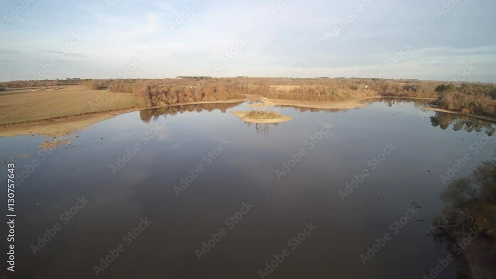 Survol d'un lac des landes avec une petite île au centre