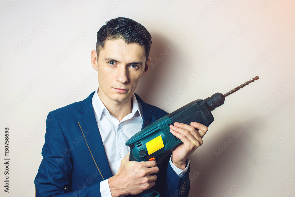 man businessman holds in hand a power drill as weapon man businessman holds in hand a power drill as weapon