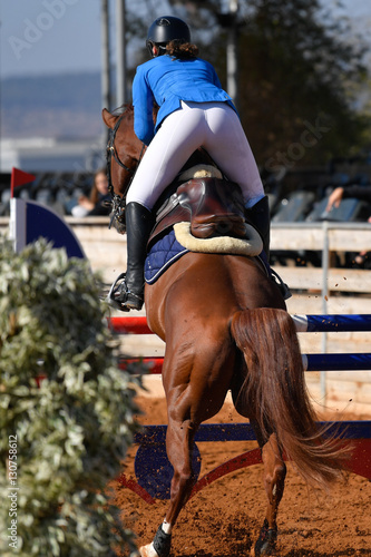 Rider on horse jumping over a hurdle during the equestrian event