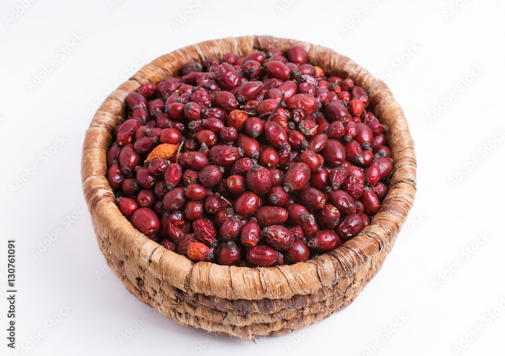 Dried rose hips in wicker basket isolated on white background Dried rose hips in wicker basket isolated on white background