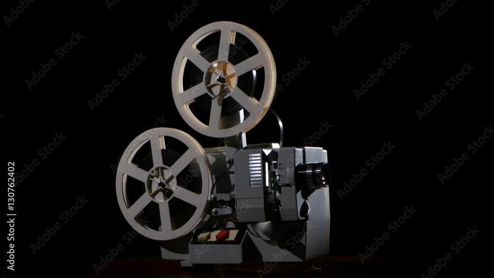 Old projector showing film. Studio black background Old projector showing film. Studio black background