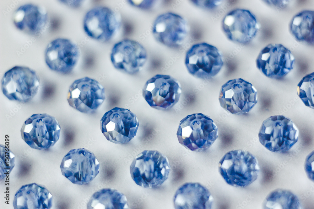 blue glass beads polyhedron shape pattern closeup on a white background blue glass beads polyhedron shape pattern closeup on a white background
