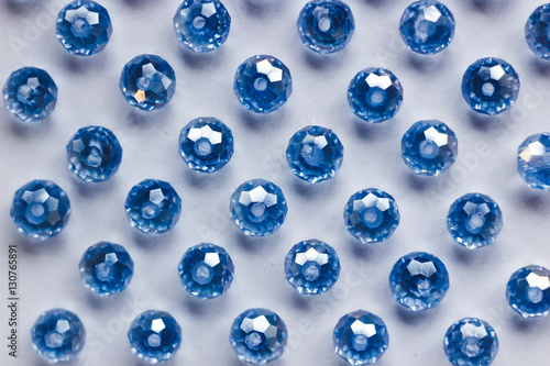 blue glass beads polyhedron shape pattern closeup on a white background