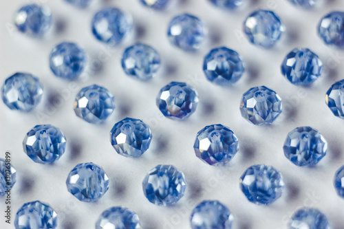 blue glass beads polyhedron shape pattern closeup on a white background