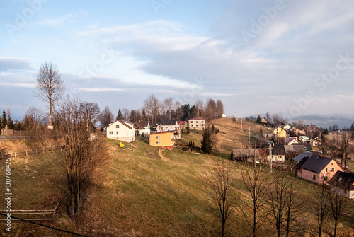 late autumn countryside with houses  fields  meadows  trees and blue sky with clouds bellow Ochodzita hill ii Koniakow village in Beskid Slaski mountains