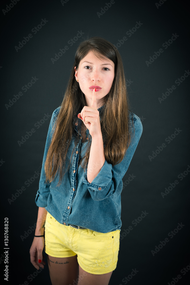 Beautiful woman doing different expressions in different sets of clothes: be quiet Beautiful woman doing different expressions in different sets of clothes: be quiet