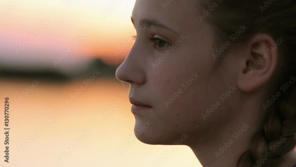 Girl face profile calm - Side view portrait of young girl relaxing by the lake at sunset. Close-up of teen girl (14-15) enjoying quiet evening on the beach. Girl face profile calm - Side view portrait of young girl relaxing by the lake at sunset. Close-up of teen girl (14-15) enjoying quiet evening on the beach.