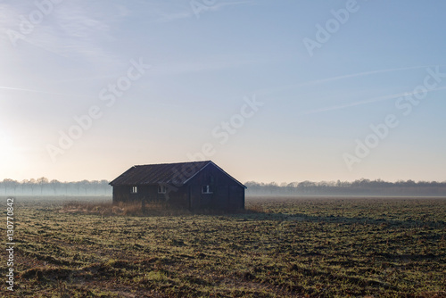 Old barn in misty farmland. Achterhoek. Gelderland. The Netherla