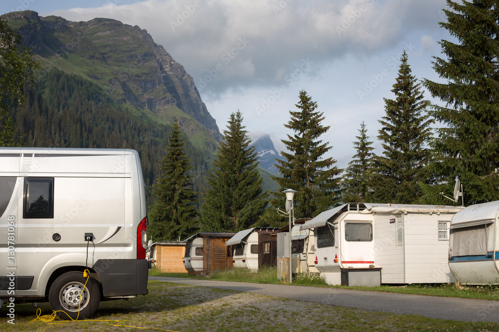 Cars and campervans in an outdoor mountain camping site staying here overnight