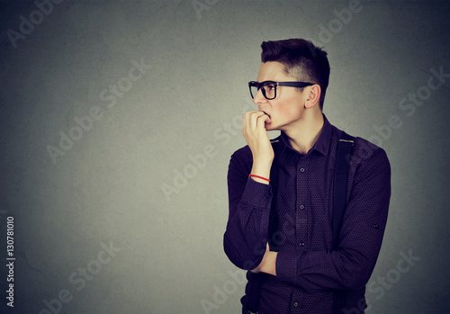 Preoccupied anxious man biting his fingernails