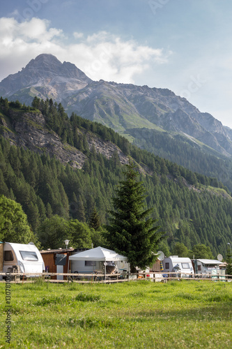 Cars and campervans in an outdoor mountain camping site staying here overnight