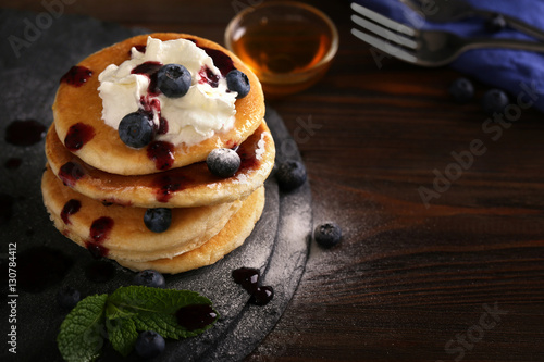 Tasty pancakes with blueberry on cutting board
