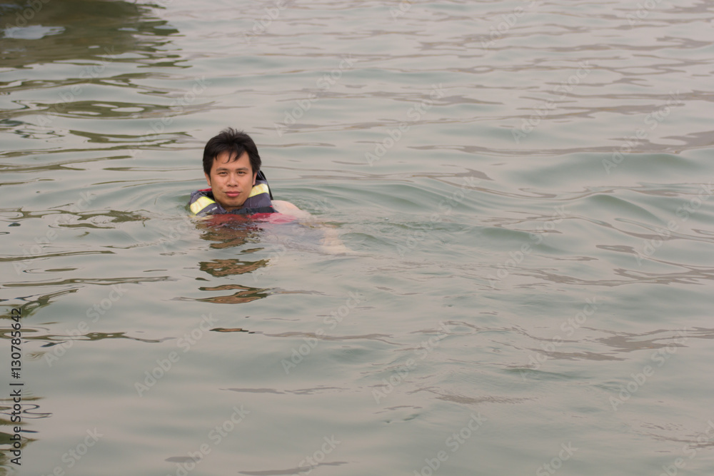 Asia man in life jackets swimming in river