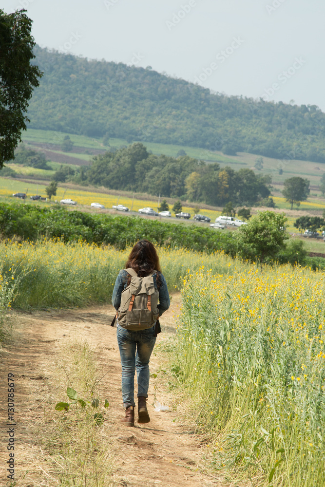 Girl wearing a backpack walking down on road alone.