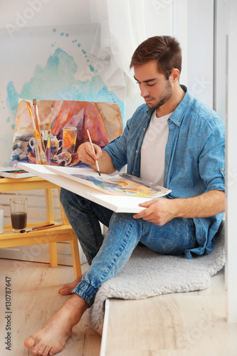 Young male artist painting ...