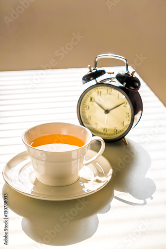 Clock and tea on office desk