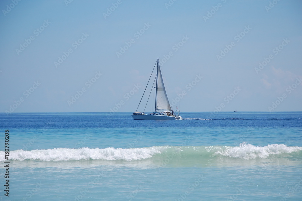 Obraz premium Beautiful lonely yacht with white sails in the ocean