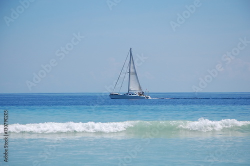 Beautiful lonely yacht with white sails in the ocean