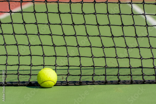 Green tennis balls are in a tennis court. © dsom