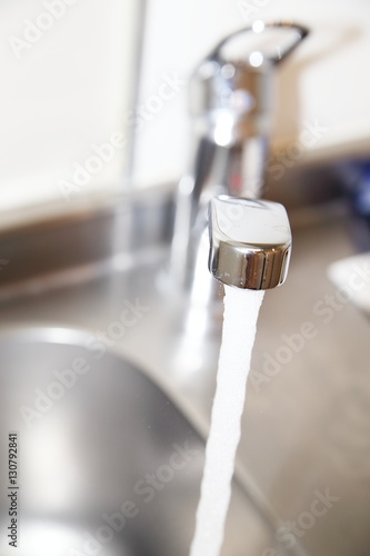 water flows from the kitchen faucet to sink