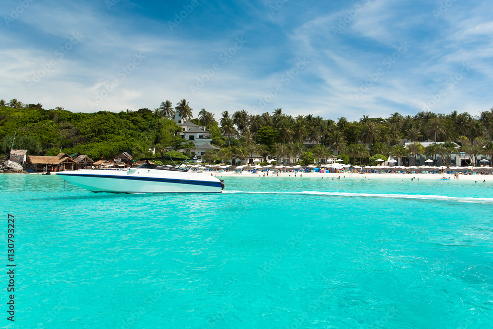 A yacht under the blue sky against a tropical beach