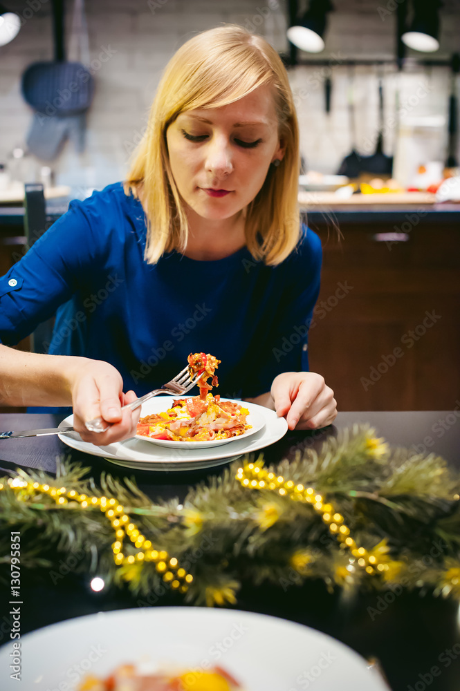 woman eating homemade food, of own preparation fried egg. breakfast for two persons, at home in the kitchen at the dining table