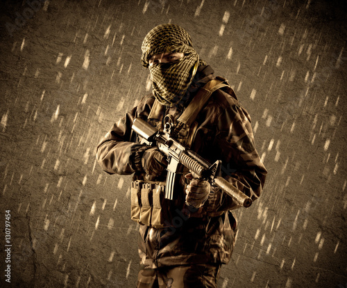 Φωτογραφία Dangerous heavily armed terrorist soldier with mask on grungy ra