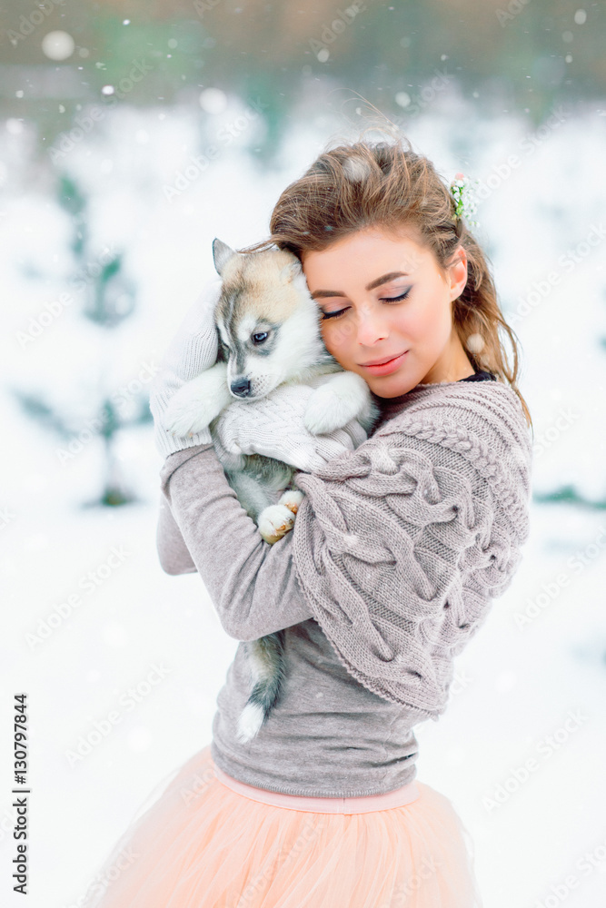 The bride hugs a husky puppy. The bride hugs a husky puppy.