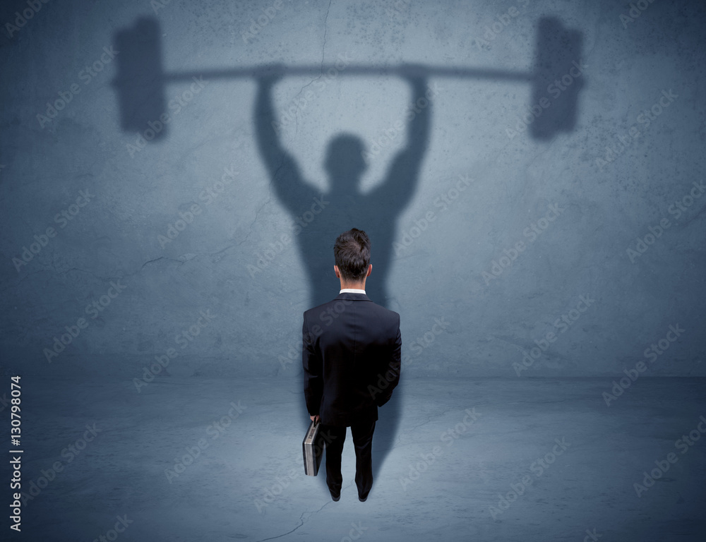 Obraz premium Businessman with weight lifting shadow