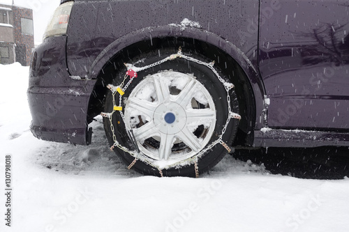 wheel of a car with chains on snow