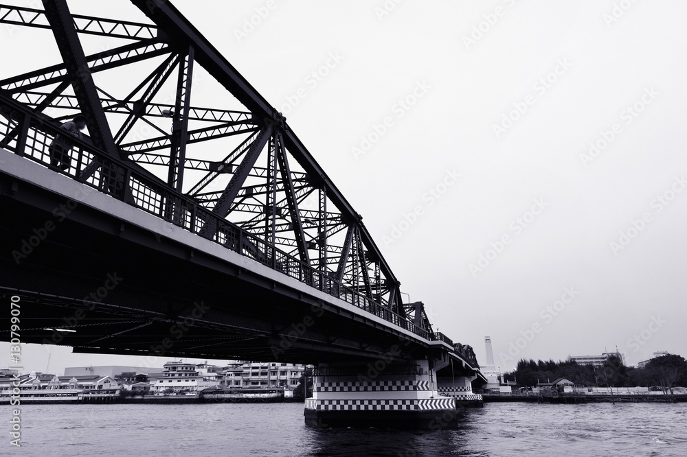 Obraz premium Black and white bridge across a Chao Phraya river