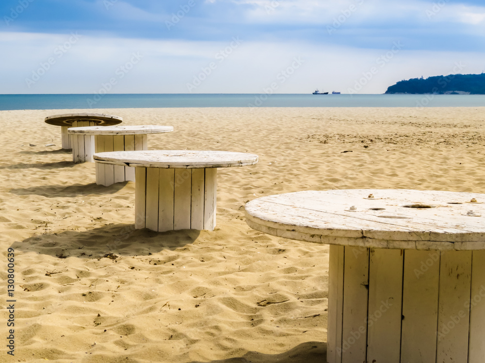 Sandy beach and wooden coils as beach little tables. Varna, Bulgaria
