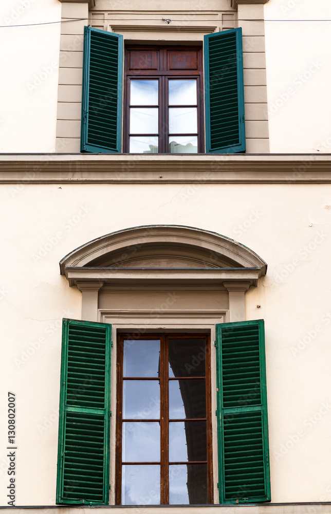 Fototapeta premium two windows with green blinds in urban house