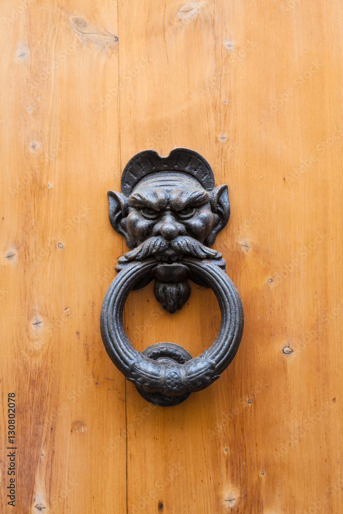 ancient male head knocker on old wood door ancient male head knocker on old wood door