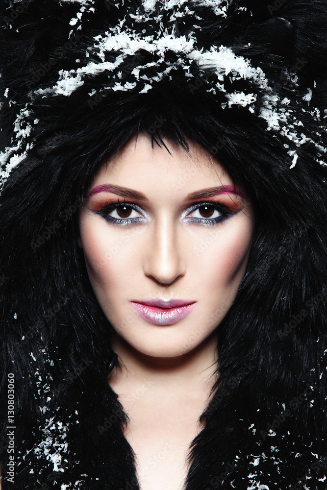 Portrait of young beautiful woman with stylish make-up in fur hat and snowflakes Portrait of young beautiful woman with stylish make-up in fur hat and snowflakes