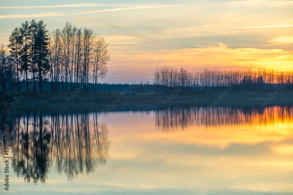 Fototapeta premium Sunset on the lake. Reflections in water.