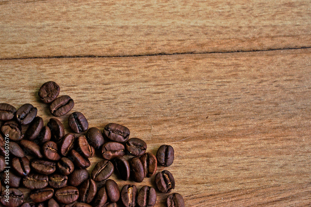 Fototapeta premium Coffee beans on a wooden table