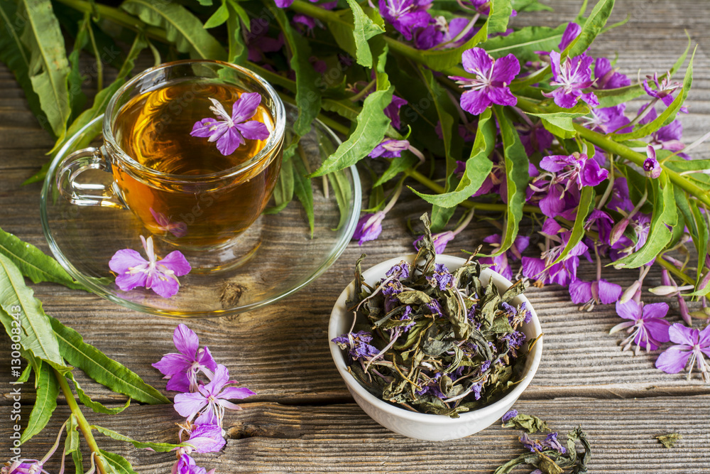 blooming Sally, collected and dried brewing herbal tea useful scattered on the wooden background with flowers a cup of . selective Focus blooming Sally, collected and dried brewing herbal tea useful scattered on the wooden background with flowers a cup of . selective Focus