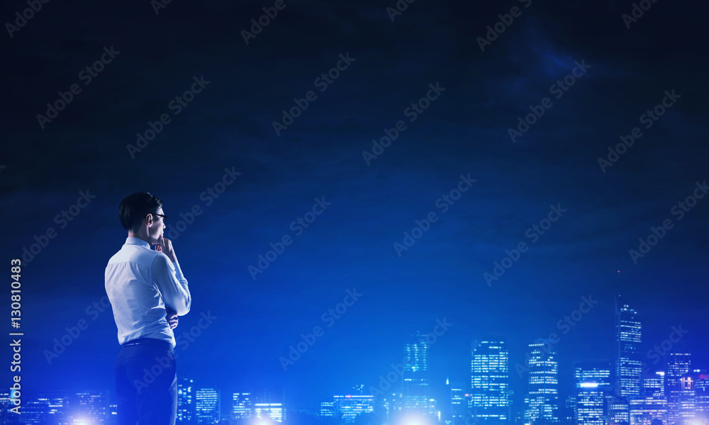 Businessman viewing night glowing city Businessman viewing night glowing city